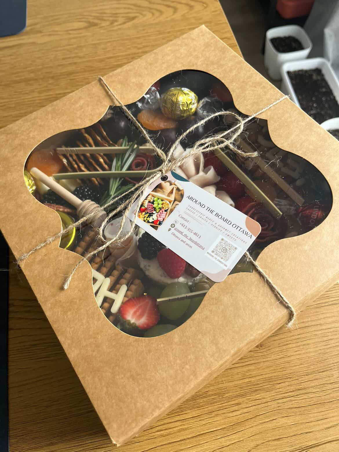 Large grazing box wrapped with twine and a branded Around the Board Ottawa card