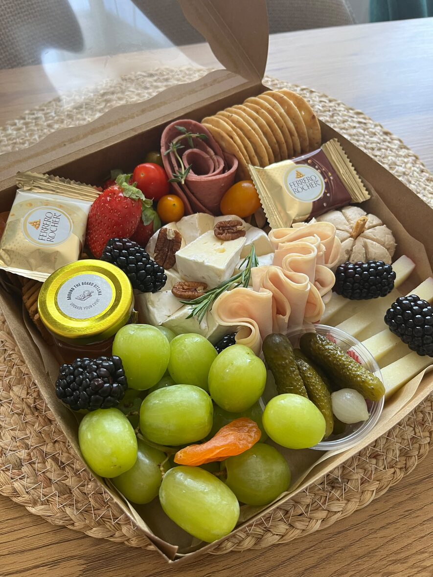 Medium grazing box close-up with brie, crackers, cherry tomatoes and berries